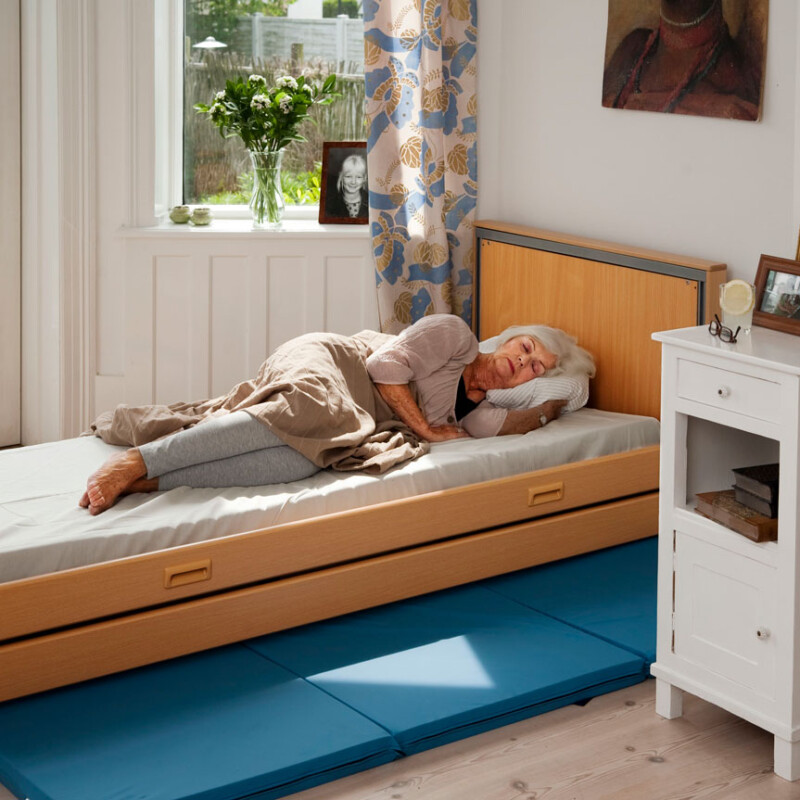 Senior woman sleeping on a be with the curtains open