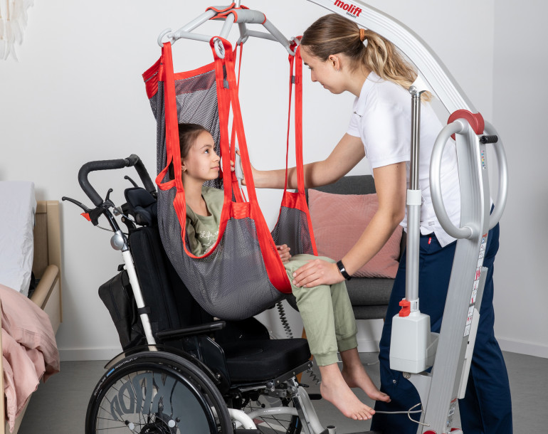 Carer with child patient in a hoist