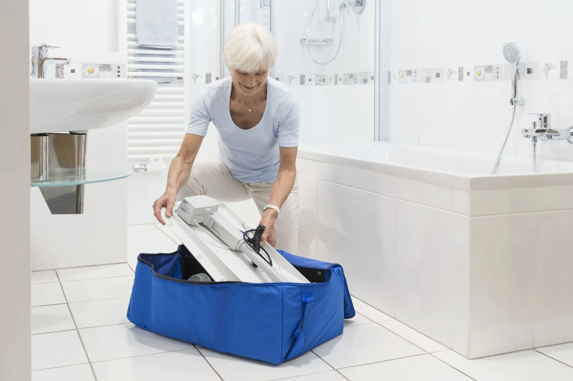 A senior woman packing away a bathroom aid into a blue bag