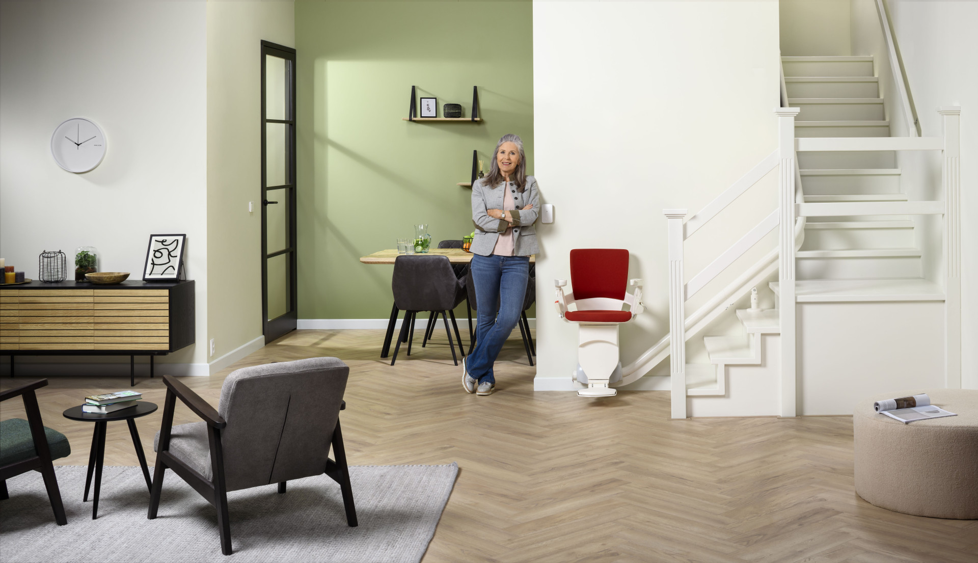A woman standing next to a stairlift in the modern living space