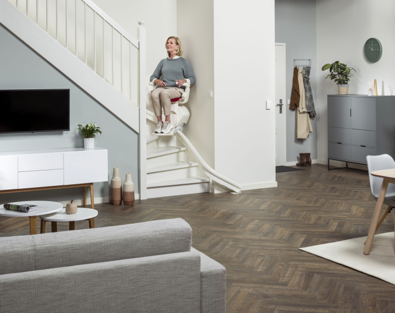 Senior woman on a stairlift in a modern home